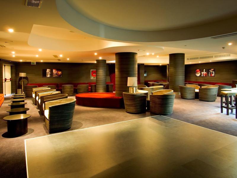 Przestronny hotelowy salon z nowoczesnymi siedzeniami i ciepłym oświetleniem.