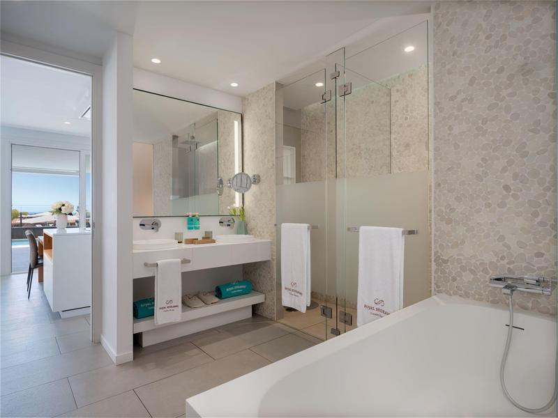 Bright bathroom with bathtub, glass shower enclosure, and modern vanity.