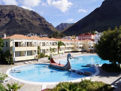 Hotel pool with gondola in front of mountain landscape and cloudy sky