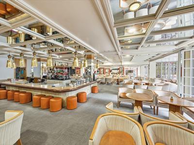 Moderne hotelbar met veel zitplaatsen en grote ramen.