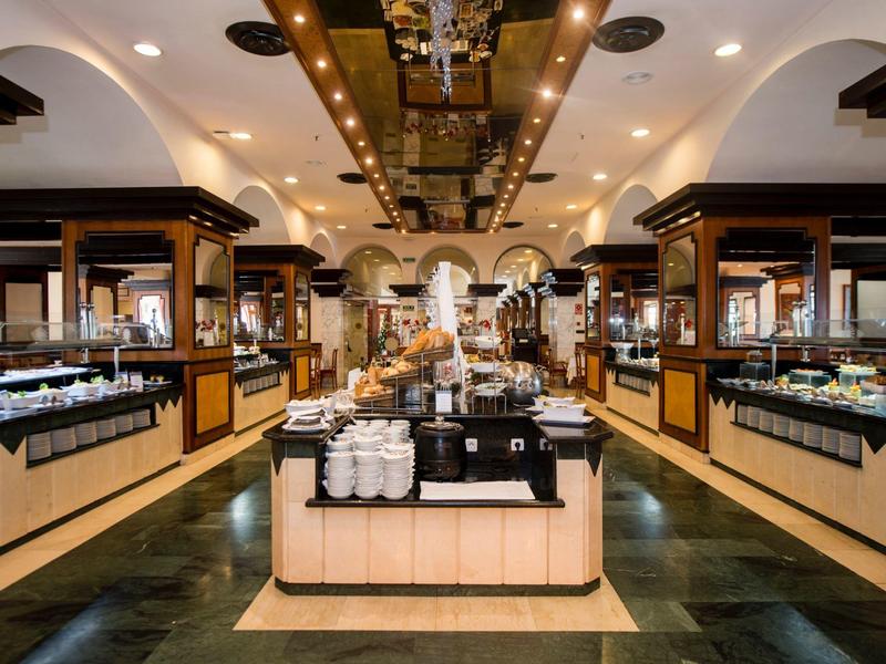 Elegante buffetruimte met donker hout, helder licht en diverse gerechten.