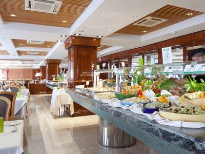 Buffet with various dishes in a bright, elegant hotel dining room.