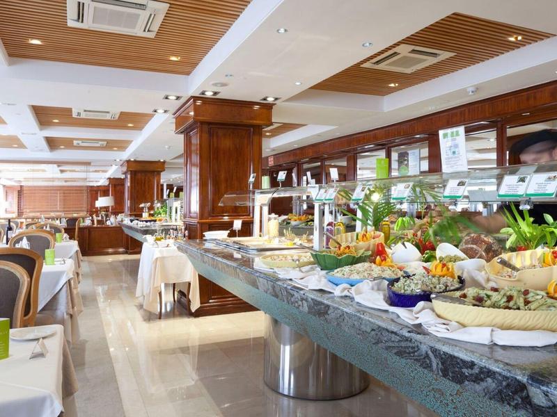 Buffet with various dishes in a bright, elegant hotel dining room.