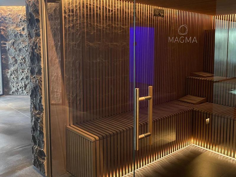 Moderner Saunabereich mit Holzverkleidung, blauer Beleuchtung und Marmorboden