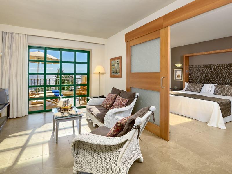 Modernes Hotelzimmer mit Doppelbett, Sitzecke, Balkon und heller, freundlicher Einrichtung.