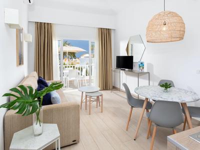 Soggiorno moderno con tavolo da pranzo, divano e balcone con vista mare.