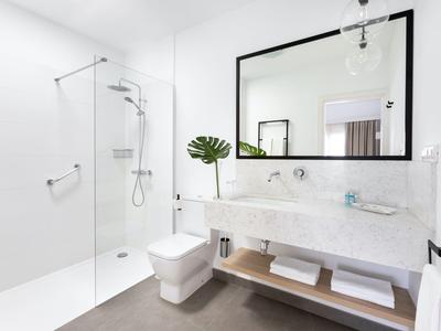 Bagno moderno e luminoso con ampia doccia, toilette e doppio lavabo con grande specchio.