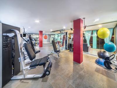 Nowoczesna sala fitness z urządzeniami do ćwiczeń, piłkami i lustrem