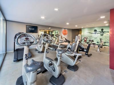 Nowoczesna siłownia z rowerami stacjonarnymi i lustrem w hotelu.