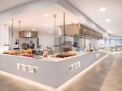 Nowoczesna otwarta kuchnia z ladą i wbudowanym bufetem w restauracji hotelowej.
