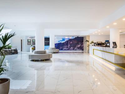 Moderní hotelová lobby s lesklou mramorovou podlahou a rostlinami