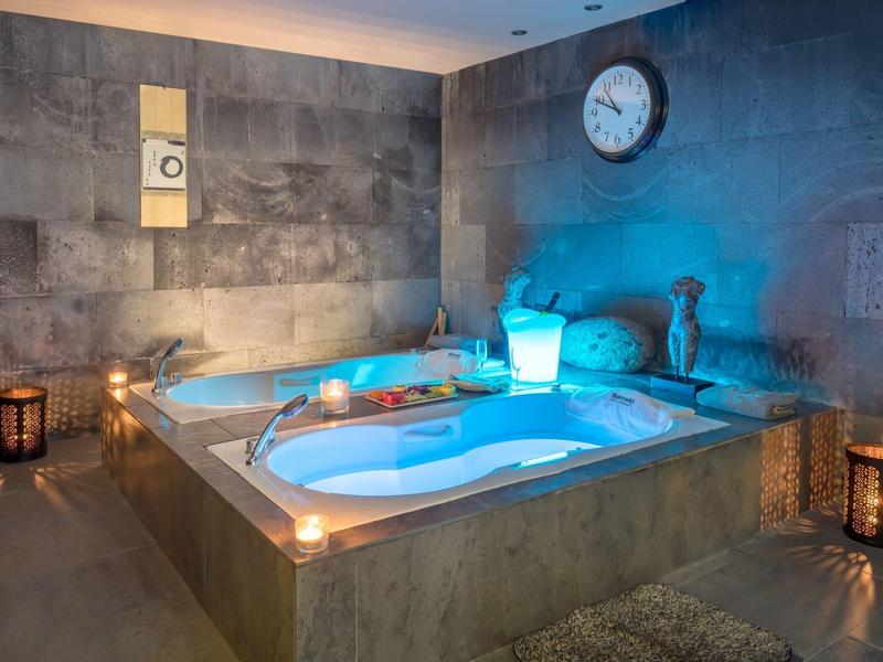 Moderní spa s osvětlenou vířivkou v klidném, tlumeném osvětlení vytvářejícím útulnou atmosféru.