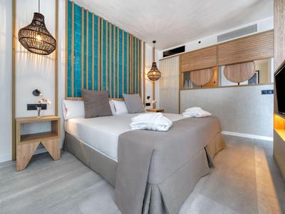 Moderne hotelkamer met tweepersoonsbed, stijlvolle lampen en kleurrijke wanddecoratie.