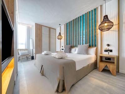 Chambre d'hôtel moderne avec lit double, meubles en bois et accents muraux élégants en bleu et bois.