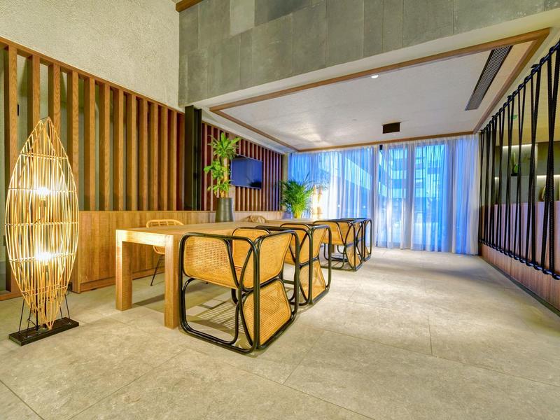 Moderne zithoek met houten bank, tafel en verlichte decoratieve lamp in een minimalistische stijl.