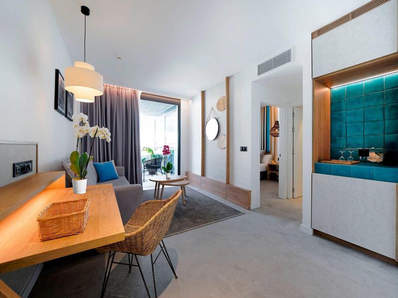 Modern hotelkamer met bureau, stoel en toegang tot het balkon.