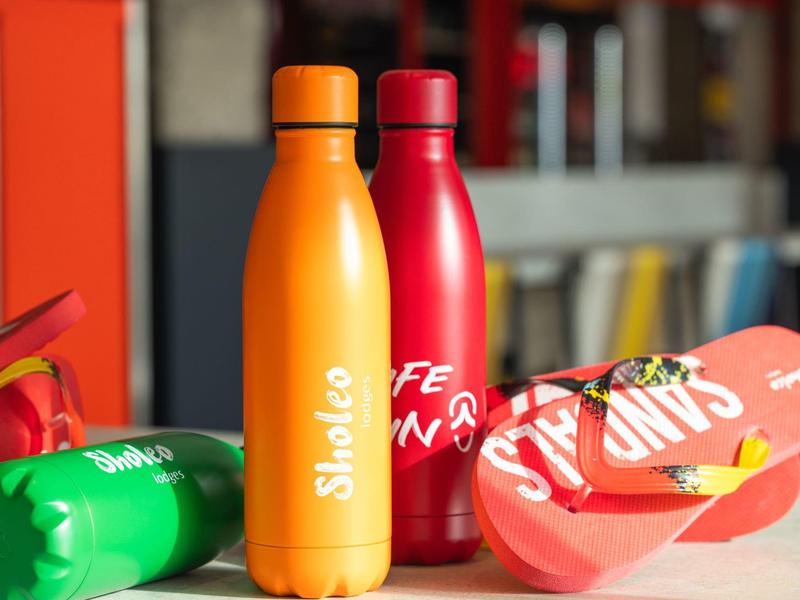 Barevné lahve na vodu a žabky na povrchu v hotelovém prostředí