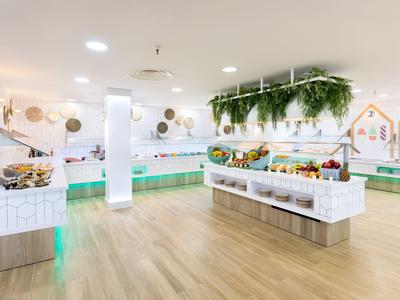 Bright, modern breakfast room with buffet and hanging plants.