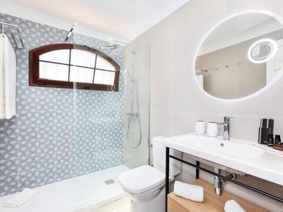 Moderner Gastraum mit hellen Holztischen, schwarzen Stühlen und sorgfältig gedeckten Gläsern.