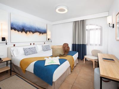 Modern eingerichtetes Hotelzimmer mit Doppelbett, Schreibtisch und hellem Fenster.