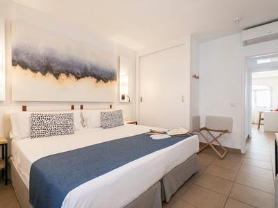 Helles Hotelzimmer mit Doppelbett, modernen Dekorationen und Flur mit Blick auf weitere Zimmer