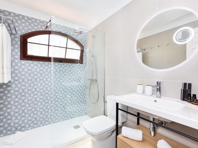 Moderner Gastraum mit hellen Holztischen, schwarzen Stühlen und sorgfältig gedeckten Gläsern.