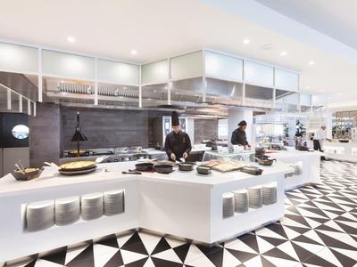 Buffet d'hôtel moderne avec comptoir blanc et motif de sol géométrique noir et blanc.