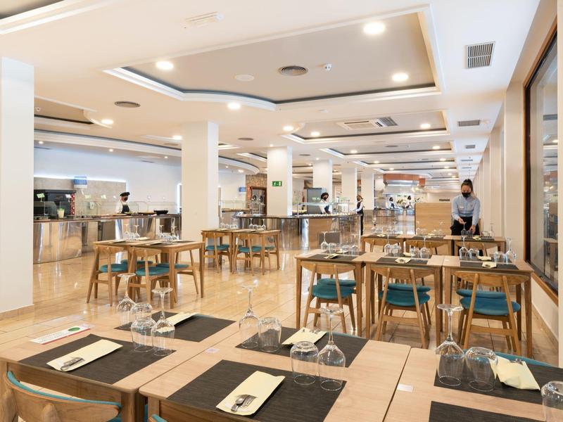 Nowoczesna jadalnia z nakrytymi stołami i drewnianymi meblami w hotelu