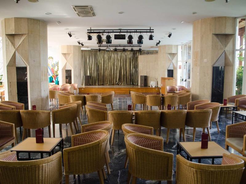 Salle d'événement vide avec des chaises et une scène dans un hôtel.