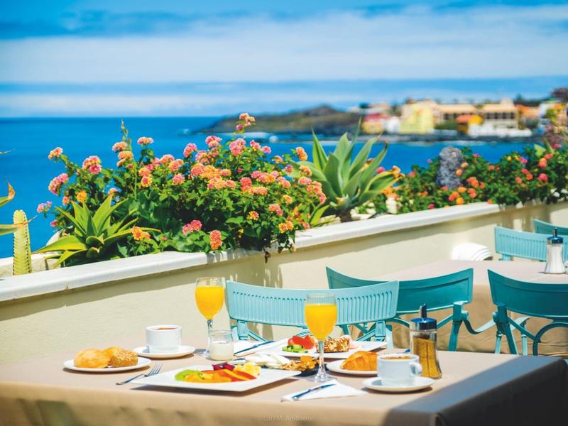 Terrace with set breakfast table and view of the sea under clear sky