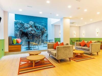Bright, modern lounge with sofas, rugs, and large aquarium walls.