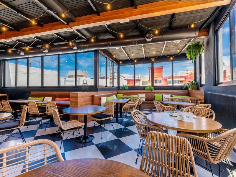 Café moderne et lumineux avec des chaises en osier et vue sur la ville