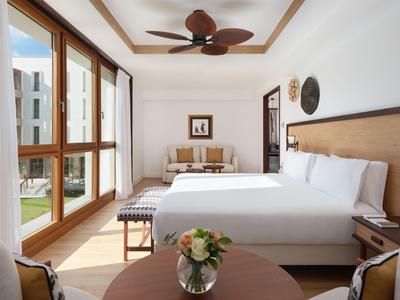 Moderne hotelkamer met groot bed, zithoek en uitzicht op de binnenplaats.
