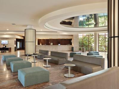 Elegante Hotellobby mit modernem Sitzbereich und großer Fensterfront.