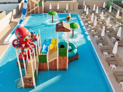 Wasserpark mit großem Pool, Rutschen und Sitzbereichen für Gäste in einem Hotelresort.