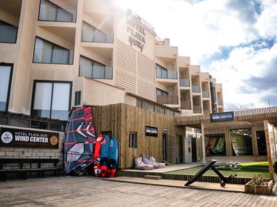 Vista esterna di un hotel con terrazza solare e attrezzatura per windsurf