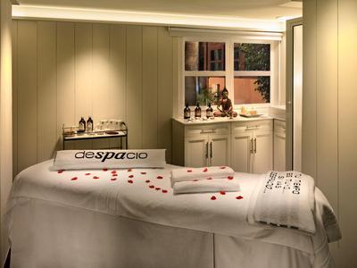 Rustige massageruimte met massagetafel, handdoeken en dimbare verlichting.