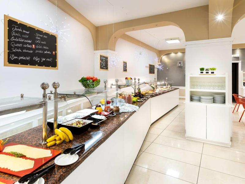 Bufé moderno con diversos alimentos y fruta fresca en un elegante comedor.