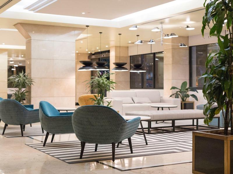 Elegante area lounge dell'hotel con poltrone moderne, divani e tavoli minimalisti.