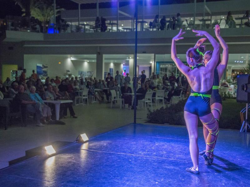 Ein Tänzerpaar führt auf einer Bühne vor Publikum eine Ballett- oder Tanzvorführung auf.