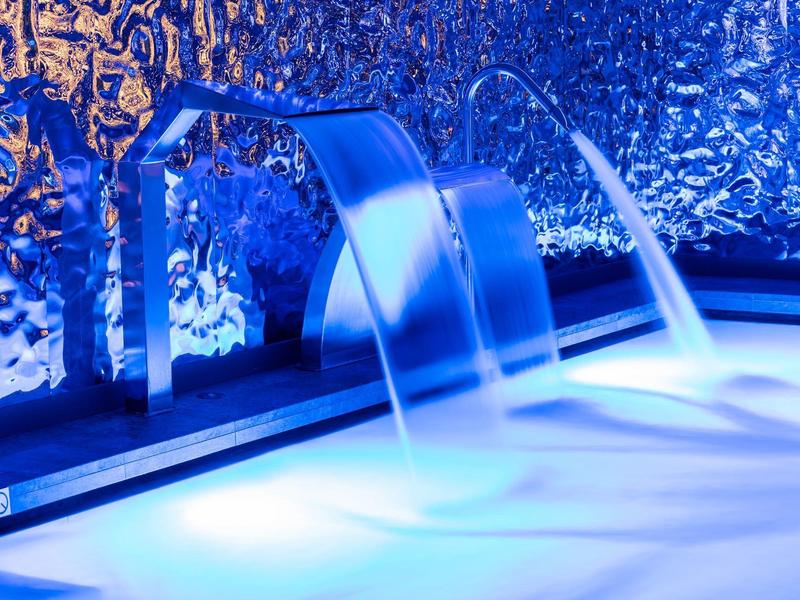 Moderner Pool mit Wasserfall-Düsen und blauem Ambientelicht