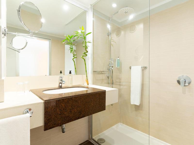 Helles, modernes Badezimmer mit weißer Duschkabine und Eichenholz-Waschbecken.