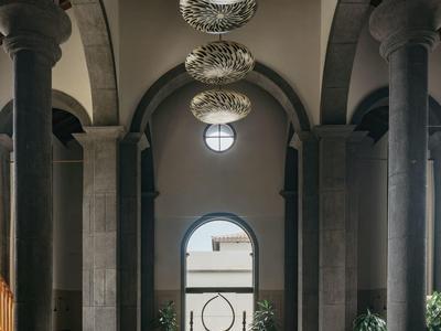 Elegancka jadalnia z wysokimi łukami, kolumnami i ozdobnymi żyrandolami.