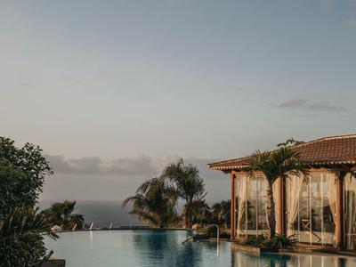 Basen infinity z widokiem na morze i zadaszona strefa wypoczynkowa pod czystym niebem.