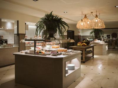 A modern buffet with various dishes and lighting in an elegant restaurant.