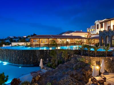 Hotel z oświetlonym basenem i tarasem nocą pod czystym niebem