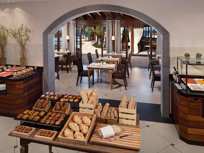 Strefa bufetu z różnymi rodzajami chleba i miejscami do siedzenia w eleganckiej restauracji.