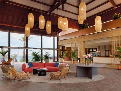 Intérieur moderne d'un espace lounge avec canapé rouge, fauteuils et grandes baies vitrées.