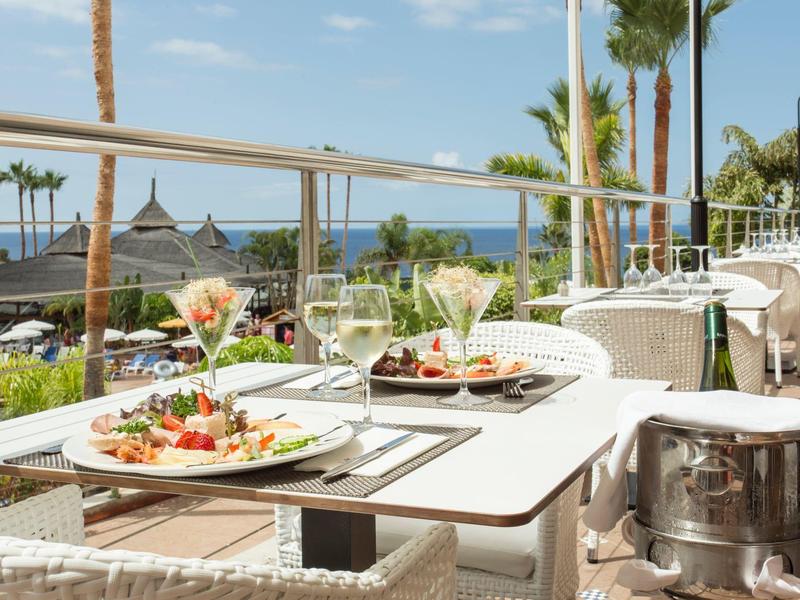 Terrace with set tables and sea view under clear sky
