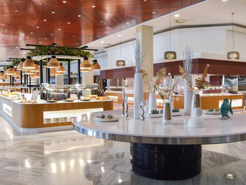 Bright buffet with various dishes and modern decor in hotel restaurant.